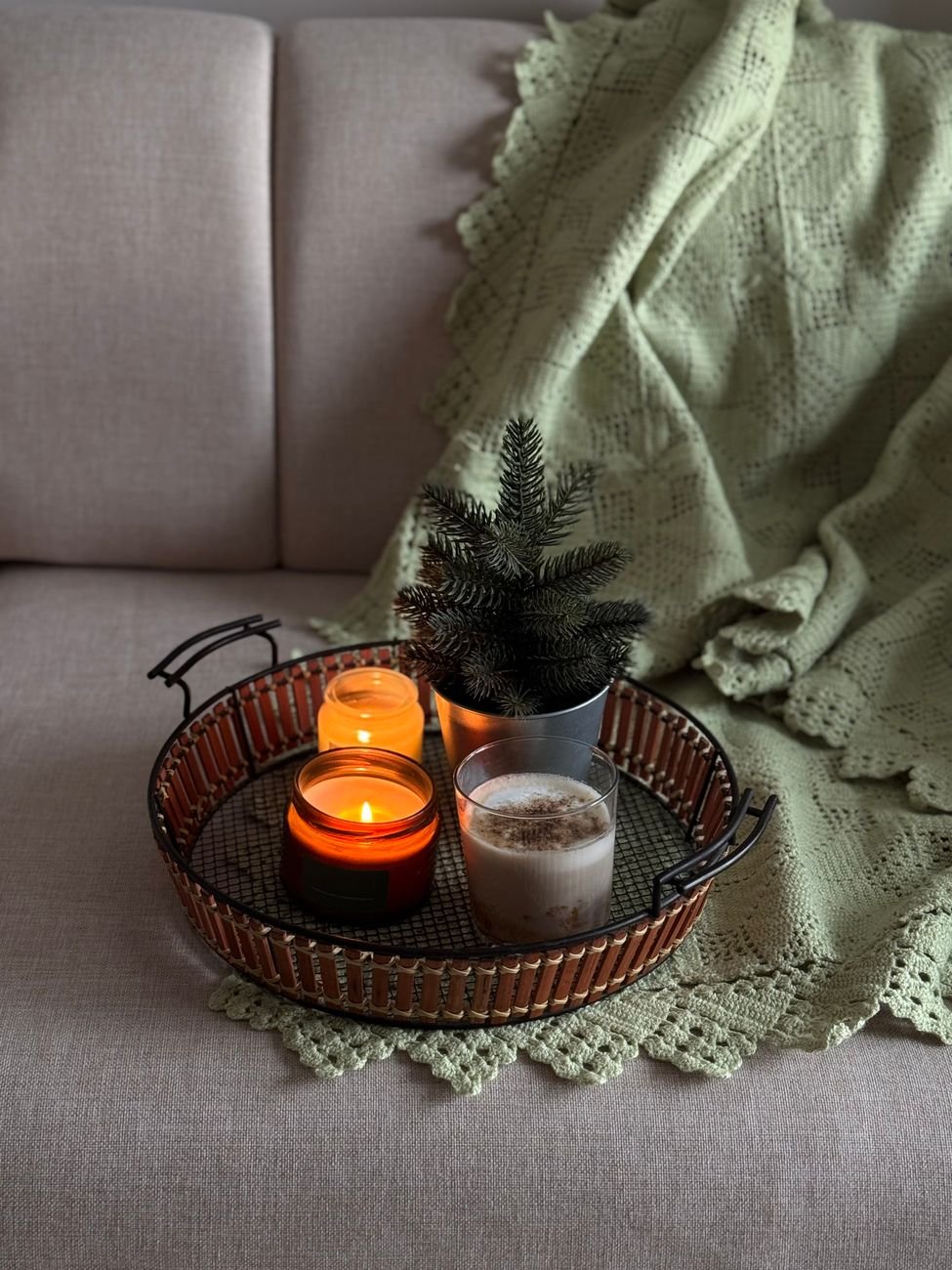 Warm, cozy scene with candles and a blanket for winter décor.